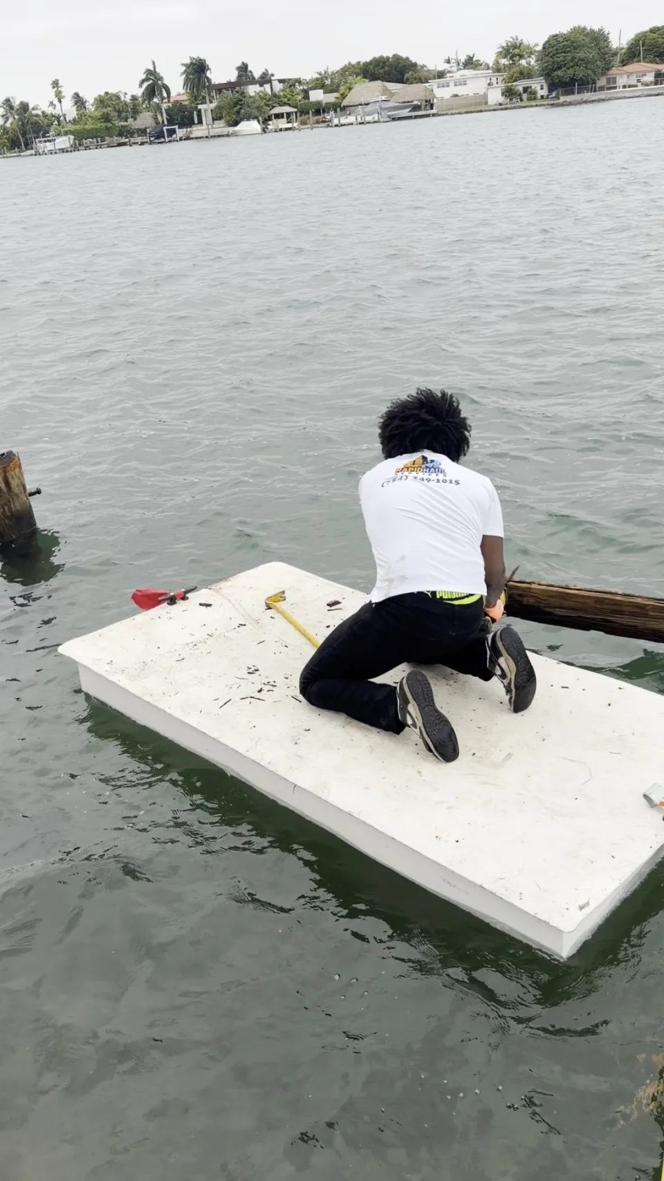 Crew member on a floating platform at an old dock piling