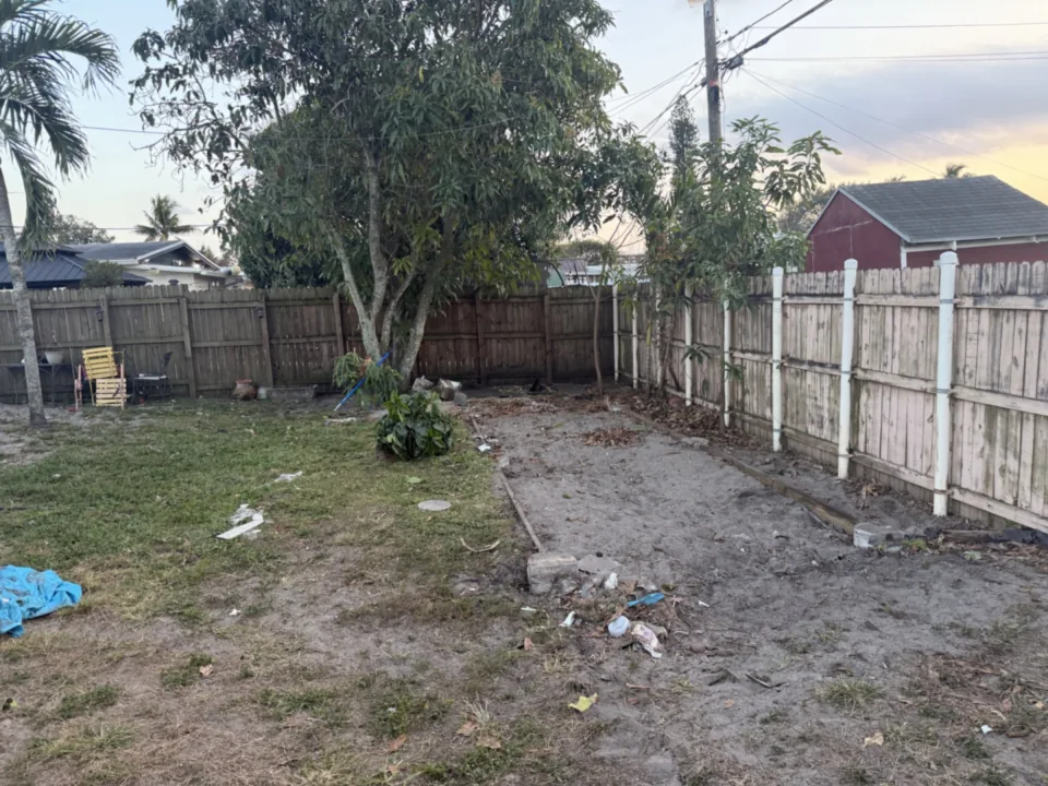 Backyard with bare dirt where the structure stood