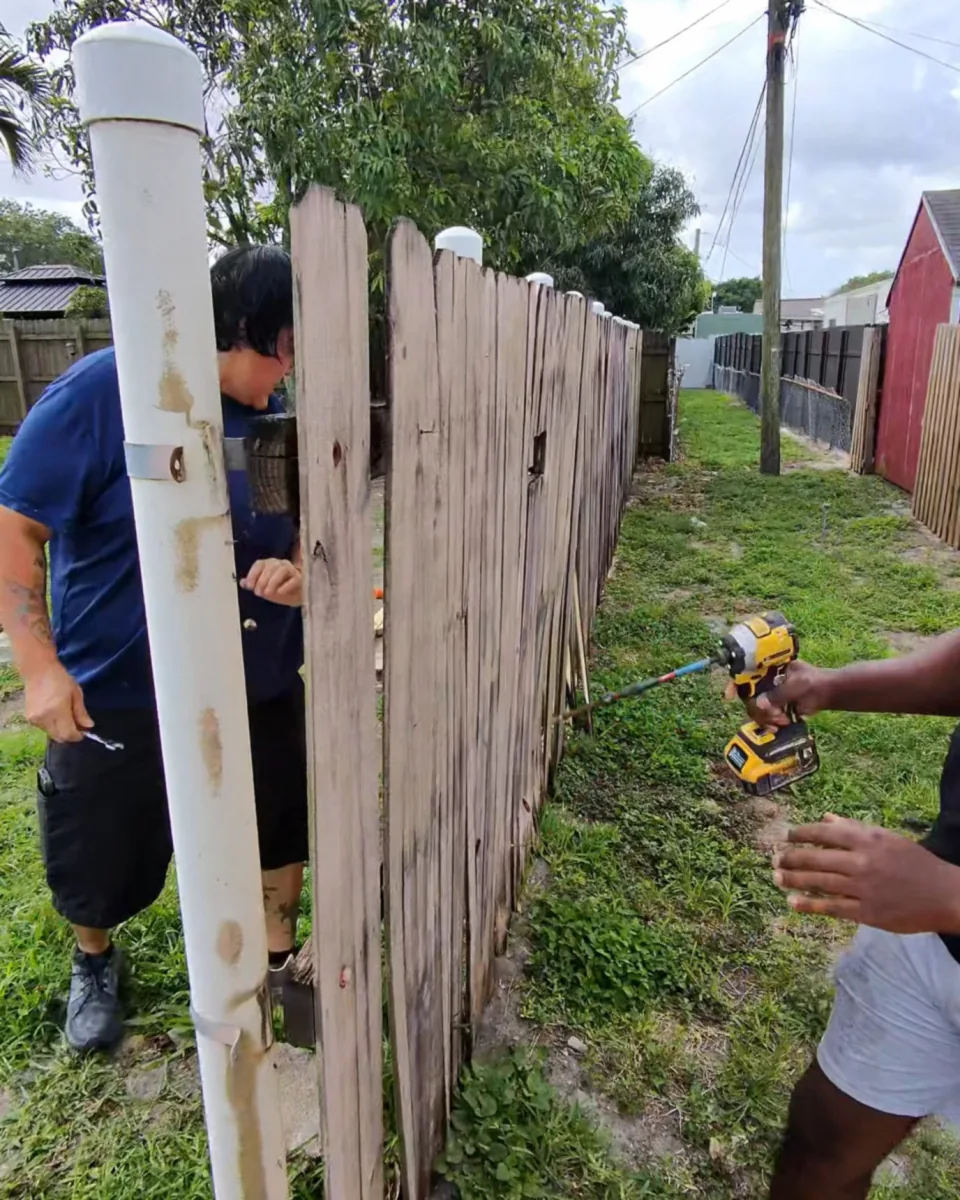 Crew member taking down a fence panel