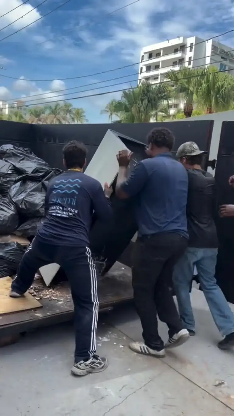 Crew loading debris bags outside the building