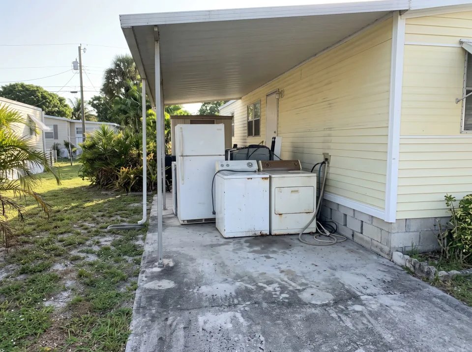 Illustration: an old refrigerator, washer and dryer wheeled out of a garage for hauling